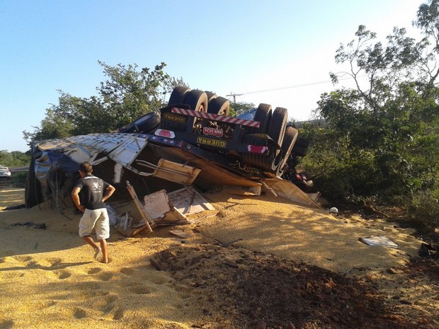 A carreta carregada de soja tombou após a colisão, espalhando a carga sobre a pista