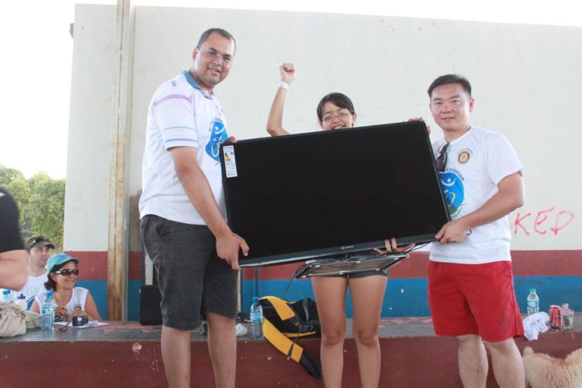 A ganhadora da TV quase some atrás do aparelho de 42"