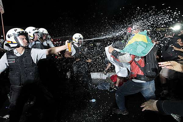 Foto de Dida Sampaio, do Estadão. Policiais de Brasília jogam spray de pimenta em manifestantes. Os jovens  responderam com bombas juninas, foguetes , sinalizadores e raios laser para confundir os policiais.