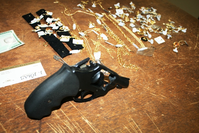 O revólver usado para o assalto e as jóias roubadas