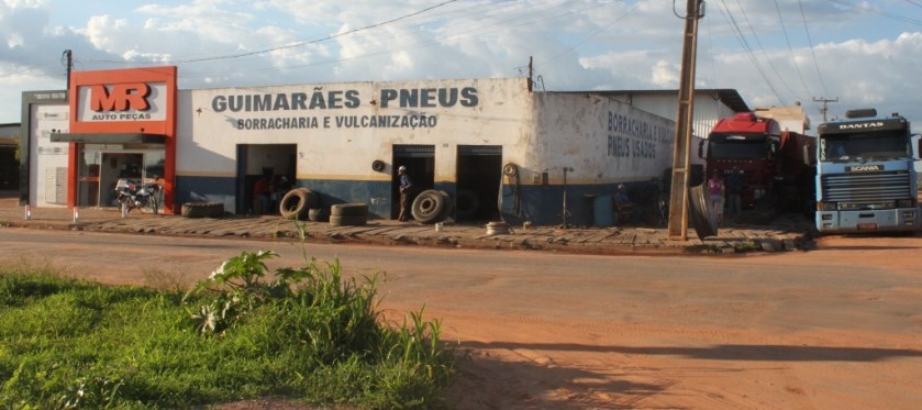 O caminhoneiro resolveu dormir na sombra. Para isso não hesitou em colocar a pesada carreta sobre o passeio. E o dono da borracharia permitiu.