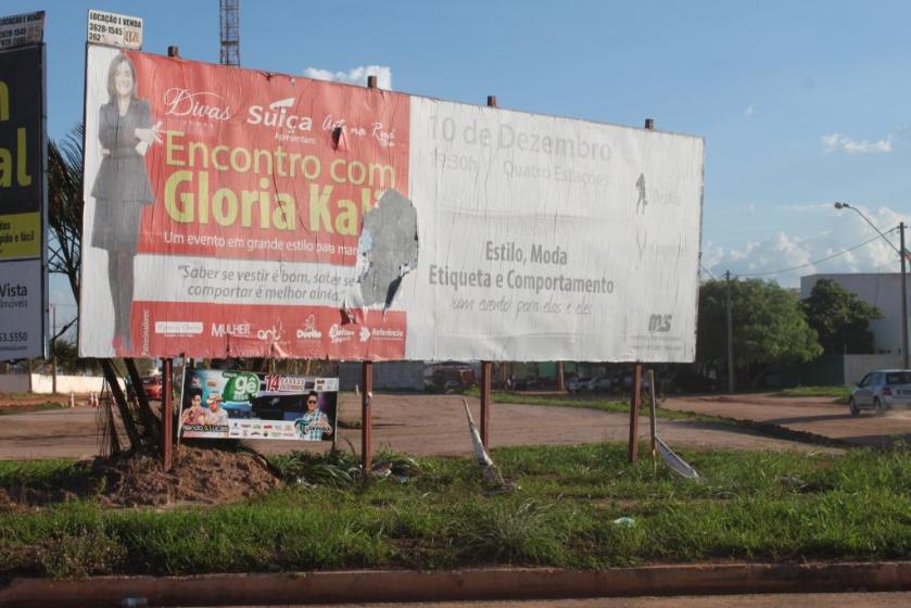 Na avenida Brasília é anunciado  um curso de etiqueta e comportamento. A tabuleta rasgada é um bom exemplo.