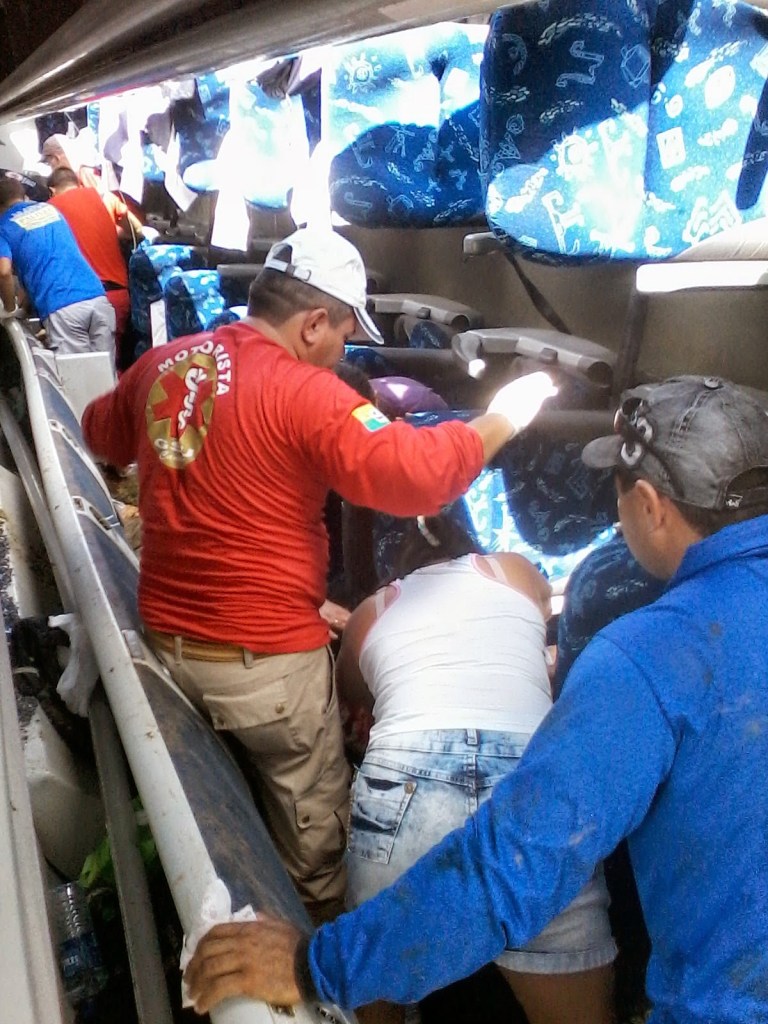 Bpmbeiros e populares socorrem as vítimas dentro do veículo acidentado: 8 corpos ficaram irreconhecíveis.