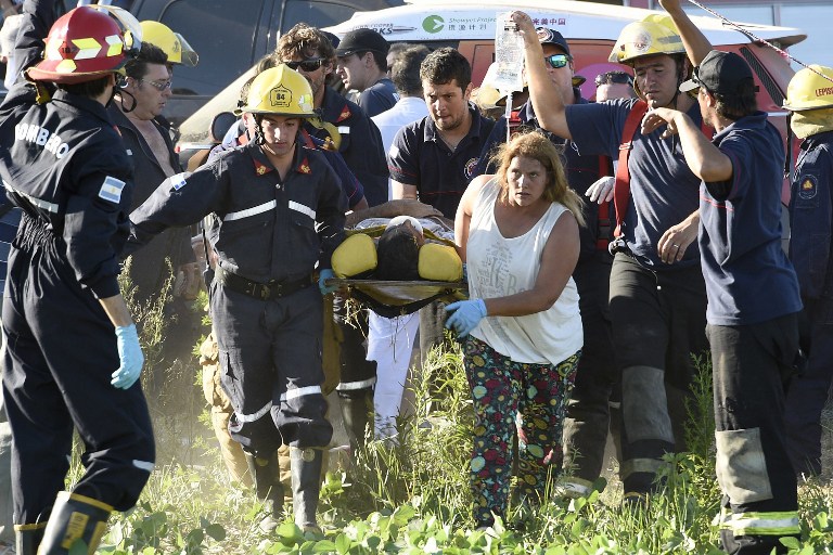 Injured spectators are assisted after Chinese driver Meiling Guo run into the crowd with her vehicle during the 11km prologue of the 2016 Dakar Rally, in Buenos Aires, on January 2, 2016. The Dakar Rally, which officially starts on January 3, will see participants race across Argentina and Bolivia in a two-week test of endurance.   AFP PHOTO / FRANCK FIFE / AFP / FRANCK FIFE