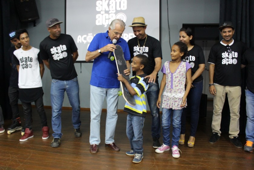 Humberto entrega, em nome do projeto Skate em Ação, um skate para Alan, aluno com necessidades especiais